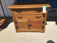 Front view of wooden cabinet showing two drawers and double door cabinet below with metal hardware.