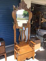 Full front view of oak hall tree showing overall structure, mirror and bench