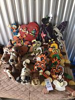 Photo showing numerous colorful wooden animal figures in various shapes such as elephants, tigers, cats, fish, butterflies, and Disney-themed characters like Donald Duck and Pinocchio.