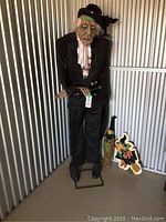 Full view of lifesize zombie butler, crow and two wooden witch decorations