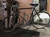 Side view of full black Puch bicycle showing frame, wheels, handlebar, and kickstand.
