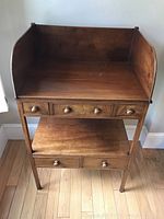 Front view of the washstand showing two-tier design, five drawers with turned wood knobs, and raised sides with splashback.