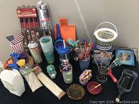 Photo showing the full lot of patio party supplies including kabob grilling baskets, straws, disposable food containers, skewers, and party utensils.