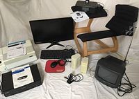 Home office electronics and furniture including monitor, keyboard, mouse, printer, VCR, CRT TV, speakers, chair, and stereo system under white backdrop.