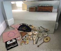 Overview of dressing table items laid out on floor in front of mirror