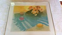 Framed artwork on table, shows entire composition with flowers, lemons, and textured shadows.