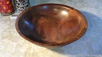 View of walnut wooden bowl showing rounded shape and polished finish