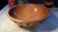 Angle view of wooden bowl showing smooth interior and some natural cracks or marks.