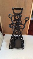 Front view of cast iron fireplace tool set assembled in stand