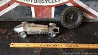 12 inch metal vintage style race car and Goodyear rubber tire wall clock shown with ruler for scale