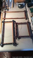 Three vintage hand carved wooden picture frames displayed on a table, showing size and overall condition.