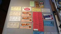 Photo showing all 15 vintage large-format business cards and advertising cards laid out on a flat surface.