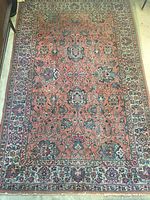 Overhead shot of full carpet showing salmon-pink field with floral medallion border