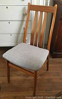 Front view showing wooden frame and grey upholstered seat