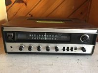 Front view of Fisher 180 stereo receiver showing multiple knobs and analog tuning dial across FM and AM bands.