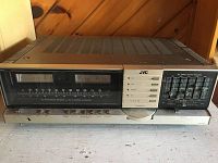 Front view of the JVC JR-S301 stereo graphic equalizer receiver showing analog tuner and sliders for equalizer and controls on metal casing.