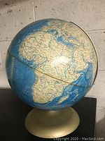 Photo showing the globe displaying Africa and parts of Europe and the Middle East, mounted on a cream-colored base.