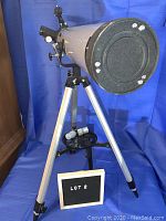 Front view of telescope on tripod with focus lens cover visible and legs at minimum height.