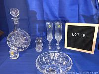 Full set view showing decanter, four flute glasses, two shot glasses, divided bowl, sugar bowl with lid and spoon.