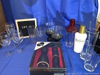 Assortment of barware including glasses, shakers, saki set in box, candle holders