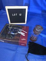 Photograph showing the corkscrew set in original box packaging alongside the wine aerator and black storage pouch.