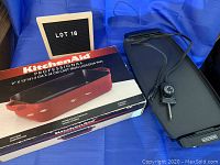 KitchenAid lasagna pan box and Black+Decker griddle with power cord on blue background.