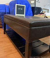 Full view of brown faux leather ottoman storage bench with slatted shelf underneath
