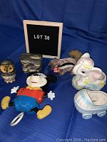 Full view of six items including Mickey Mouse pull string toy, owl alabaster ornament, TY squirrel stuffed animal, elephant and baby carriage ornaments, metal money box
