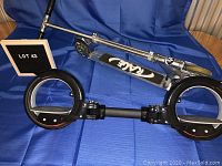 Two-wheel X8 skate cycle and Rage kick scooter with fold-down handlebars displayed on blue fabric background.