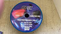 Top view of the spool with the Power Pro Audio label showing 100ft 4 gauge power cable in blue model POW-04-100BL