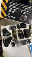 Photo of components of Lanzar silk dome tweeters including mounting parts within styrofoam packaging and box with product details.