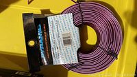 Photo of purple flat coiled speaker cable with original label showing brand Pyramid, model RSW16100, 16AWG specification and 100 length.
