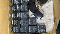 Multiple SUNTECH 12V relays arranged in a box, showing brand and technical specifications.