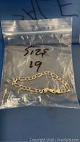Mens size 19 silver bracelet shown inside clear resealable plastic bag labeled with size 19.
