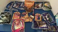 Photo showing multiple new sealed McDonald's collectible toys including Harry Potter character figures, Sharkboy & Lavagirl toys, and other collectibles laid out on a blue cloth.