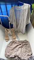 Photo showing beige knit open front top, beige shorts and nude Steve Madden ankle strap heels.