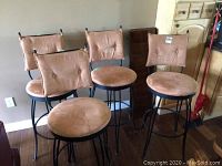 Four stools arranged against wall, front view