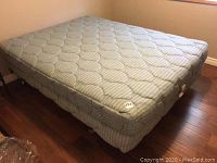 Top view of pillow top mattress on box spring showing quilted pattern and light blue striped cover.