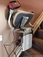 Side view of stair lift chair on straight rail with charger attached