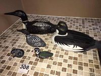 Group photo showing two large bird decoys, two smaller bird carvings, and the soapstone otter on tiled surface.