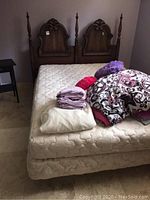 Full view of the Dielcroft double bed including mattress, box spring, and bedding piled on top.