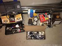 Overview of aluminum exhaust tubing, boxed keypad lever, Black+Decker charger, other miscellaneous items