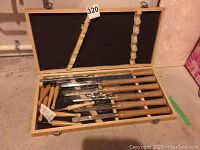 Overview of wooden case with foam insert holding multiple lathe chisels and turning tools.