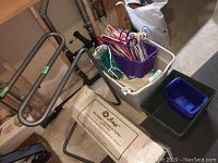 QSnap quilting frame with stand, white and purple storage bins containing hangers and fabric.