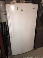 Front view of white Maytag upright freezer, door closed
