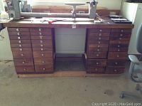 Front view of the wooden workbench highlighting both drawer pedestals and top surface items