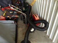 Front angle view of the yard vacuum unit with coiled hose