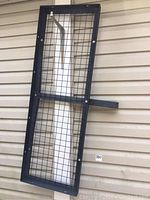 Full view of the cargo hitch carrier platform showing mesh grid and square tubing frame.