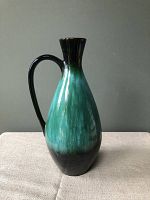Front view of a 14-inch Blue Mountain Pottery ceramic pitcher with a curved handle and green-black gradient glaze.