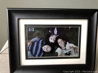 HP 7-inch digital picture frame with image displayed in black wooden frame.